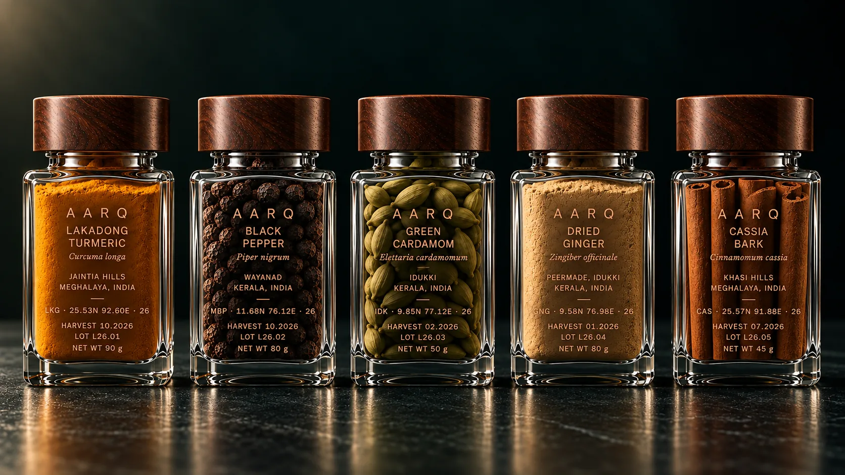 Five AARQ glass jars in a row: turmeric, black pepper, cardamom, ginger and cassia